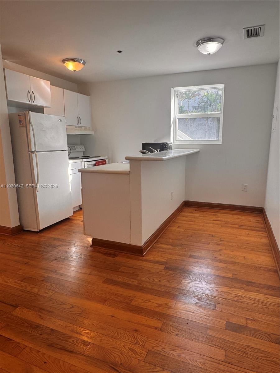 361 Collins Avenue, Unit A2 Miami Beach, FL 33139 - Photo 22 of 25 a room with wooden floors and white walls