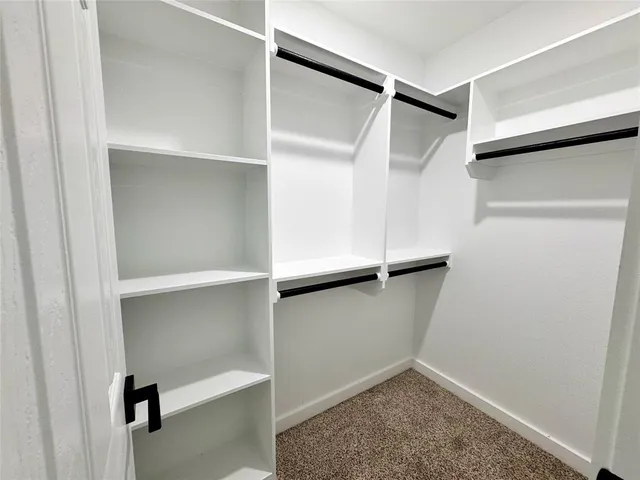 a view of walk in closet with empty racks