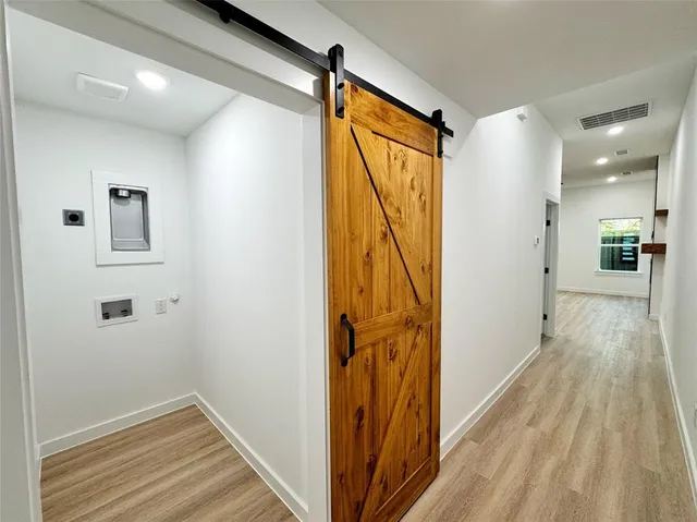 a view of a hallway with wooden floor and staircase