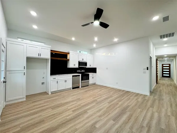 a view of kitchen with refrigerator microwave and stove