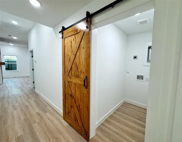 a view of a hallway with wooden floor and staircase