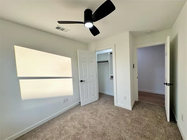 en empty room with window and ceiling fan