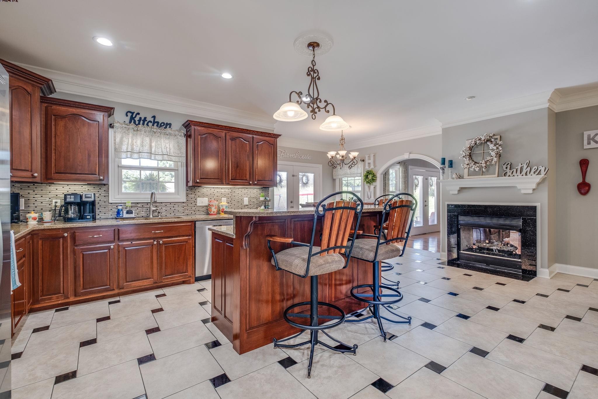 471 Penny Morris Road Portland, TN 37148 - Photo 6 of 33 a open kitchen with granite countertop a stove top oven a sink a dining table and chairs