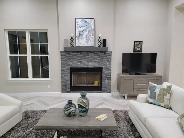 a living room with furniture a fireplace and a chandelier