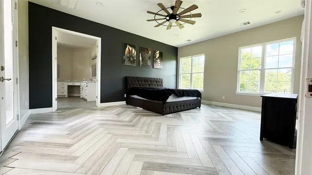 an empty room with windows and fan