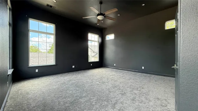 an empty room with a window and a ceiling fan
