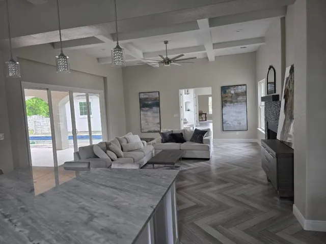 a large kitchen with stainless steel appliances granite countertop a stove a sink dishwasher a microwave oven and a refrigerator with wooden floor