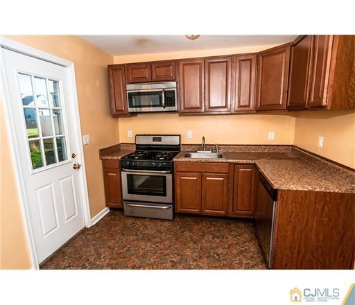 72 Sturgis Road Edison, NJ 08817 - Photo 14 of 15 a kitchen with stainless steel appliances kitchen island granite countertop a sink stove and microwave