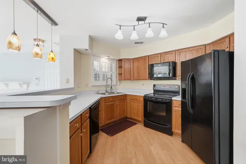 a kitchen with stainless steel appliances a sink refrigerator and microwave