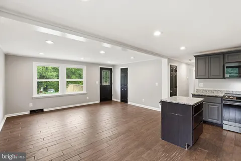 an empty room with windows and ceiling fan