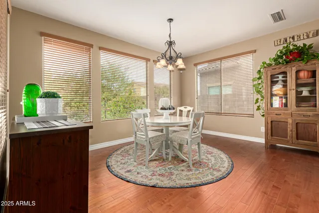 a view of a dining room with furniture a chandelier and wooden floor