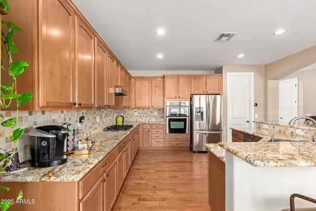 a large kitchen with kitchen island granite countertop lots of white cabinets appliances and furniture