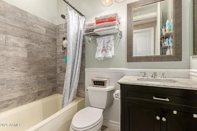 a hallway with white cabinets and black refrigerator