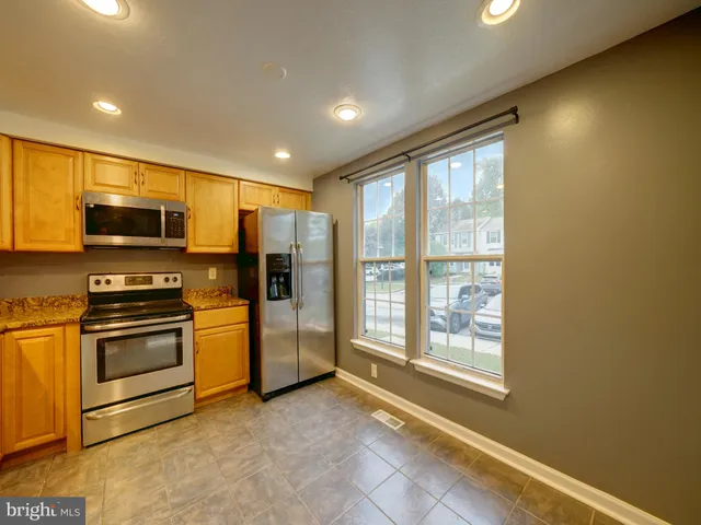 a kitchen with stainless steel appliances a refrigerator and a stove top oven
