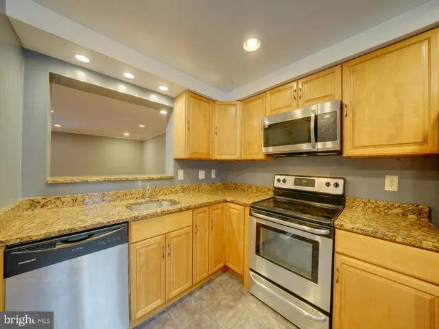 a kitchen with stainless steel appliances a stove sink microwave and cabinets