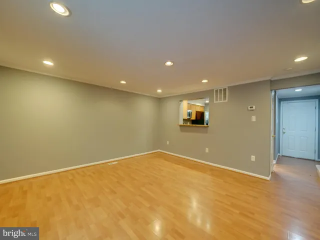 a view of an empty room with wooden floor