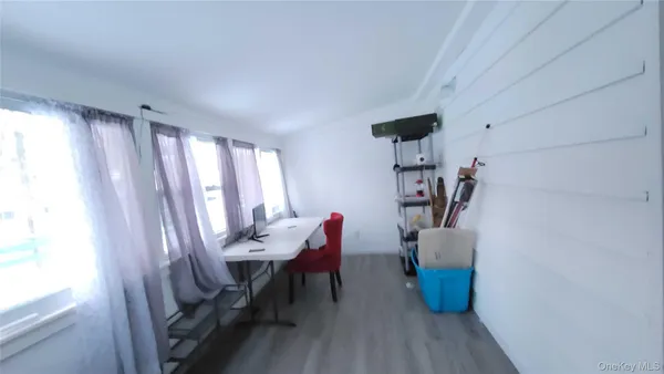 a view of a workspace with furniture and a window