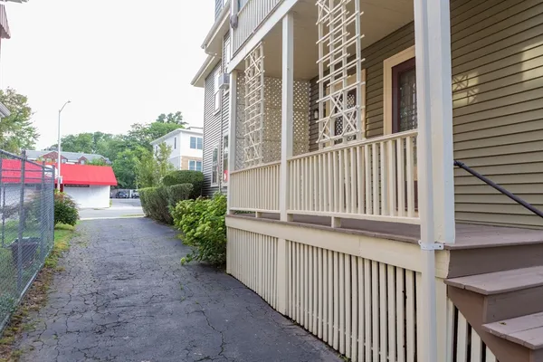 a view of a house with a yard and potted plants