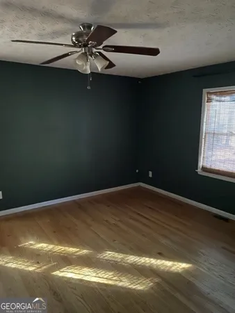a view of wooden floor and a chandelier fan in a room