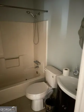 a white toilet sitting next to a bath tub and a shower