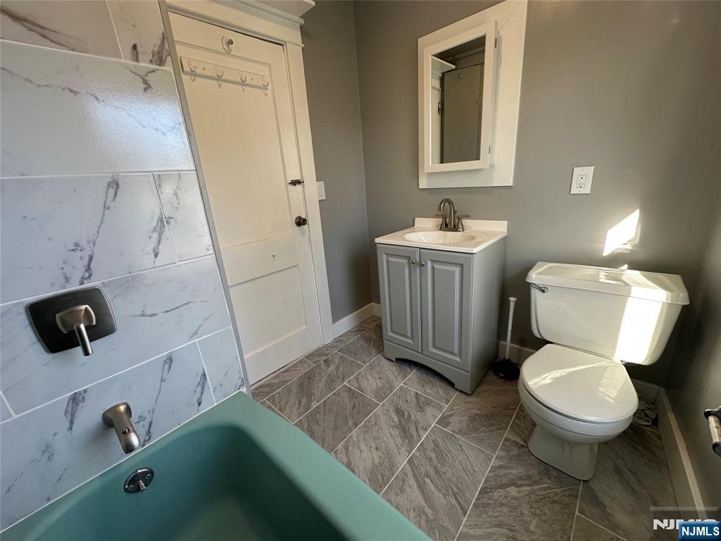 23 South 1st Street, Unit 2 Bergenfield, NJ 07621 - Photo 5 of 12 a bathroom with a toilet sink and mirror