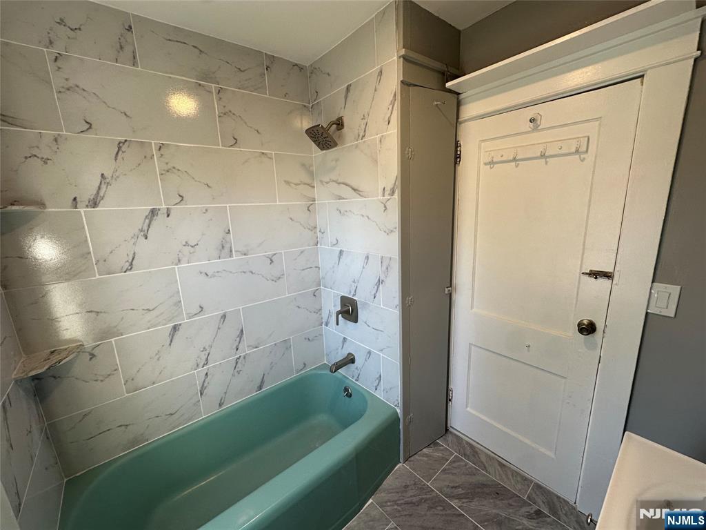 23 South 1st Street, Unit 2 Bergenfield, NJ 07621 - Photo 6 of 12 a bathroom with a shower and a tub