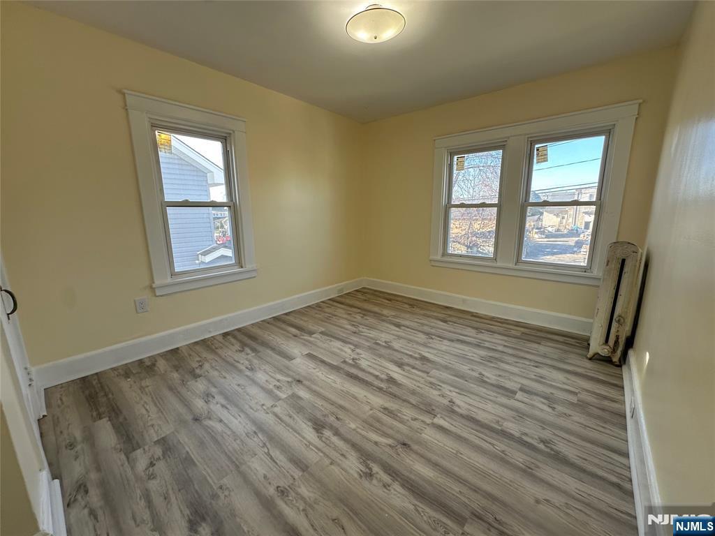 23 South 1st Street, Unit 2 Bergenfield, NJ 07621 - Photo 7 of 12 a view of an empty room with wooden floor and a window