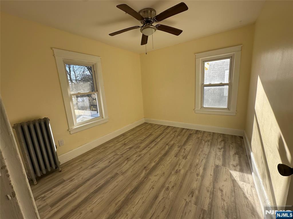 23 South 1st Street, Unit 2 Bergenfield, NJ 07621 - Photo 8 of 12 a view of an empty room with a window and wooden floor