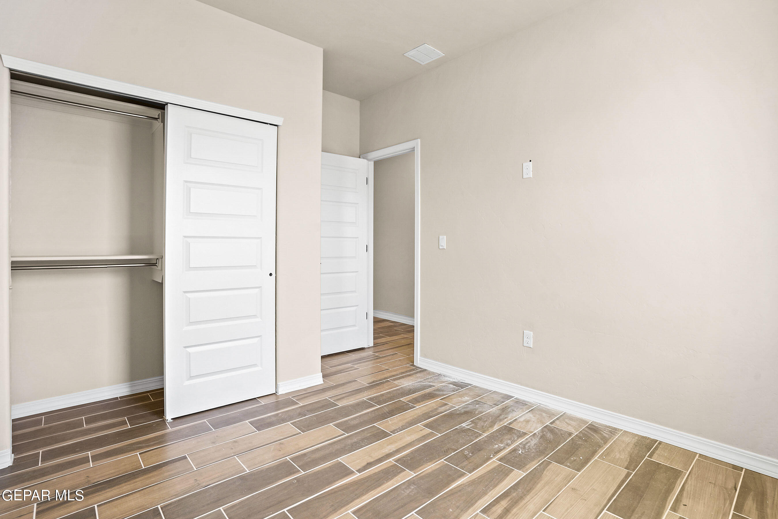871 Country Club Road, Unit 4E El Paso, TX 79932 - Photo 21 of 34 a view of an empty room with wooden floor and a window