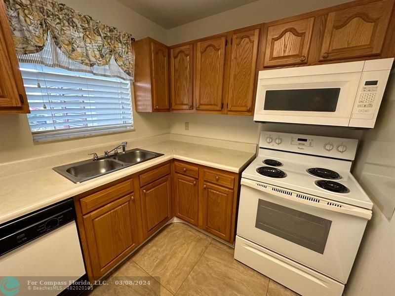 a kitchen with granite countertop cabinets washer and dryer