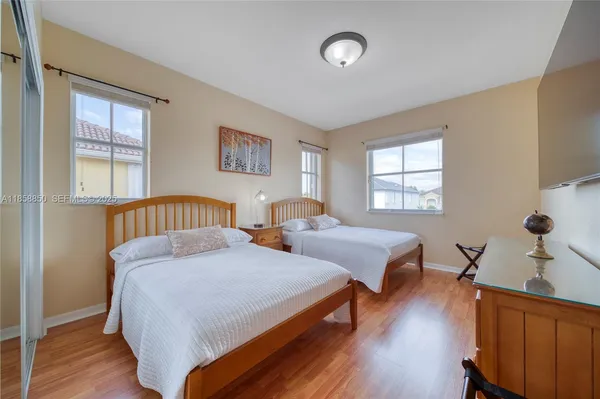a bedroom with two beds and wooden floor