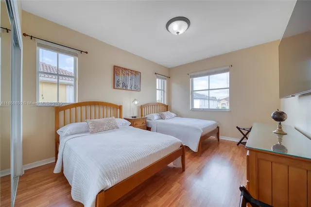 a bedroom with two beds and wooden floor