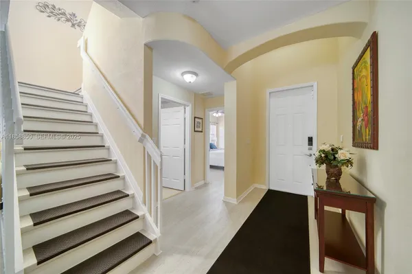 a view of a hallway with wooden floor and staircase