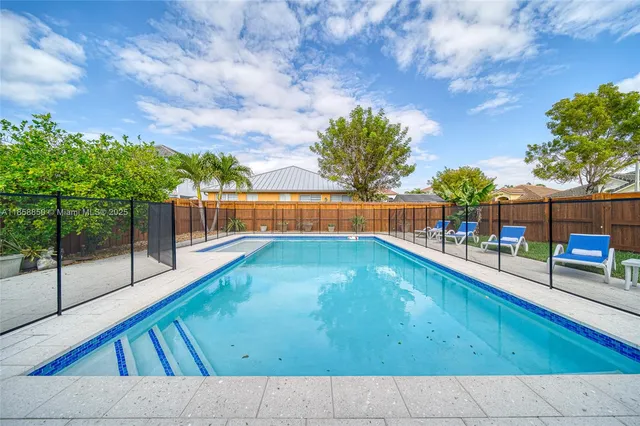 a view of backyard with swimming pool and outdoor seating