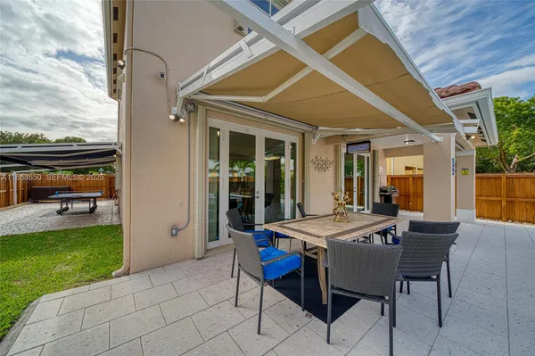 a view of a patio with table and chairs and potted plants