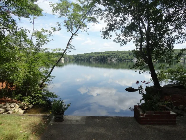 a backyard of a house with lots of green space and lake view