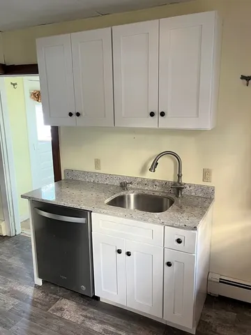 a kitchen with white cabinets and sink