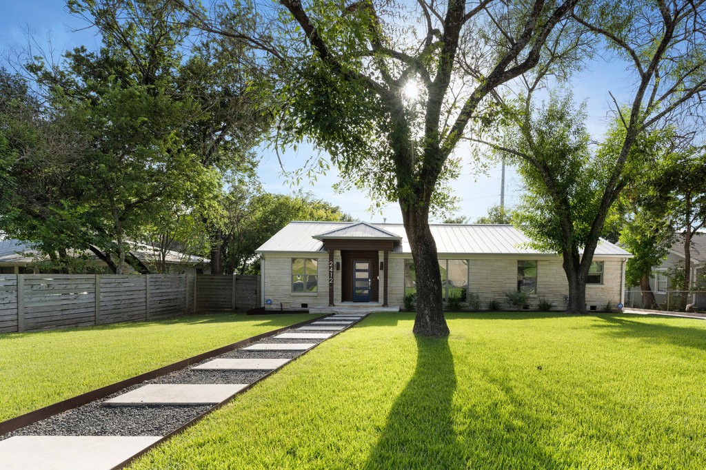 a front view of a house with swimming pool and trees