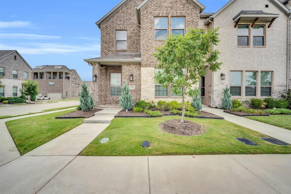 1498 Weston Road Dallas, TX 75234 - Photo 1 of 24 Brick and stone facade featuring multiple windows, a covered entry, and established landscaping
