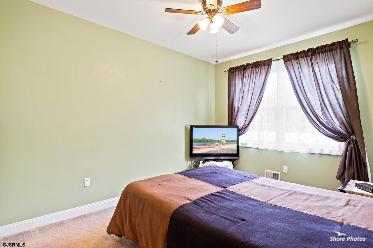 49 Killdeer Hill Road Woodbine, NJ 08270 - Photo 25 of 56 a bedroom with a bed and a chandelier