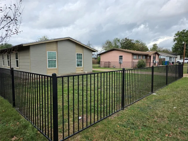 a view of a house with a yard and fence