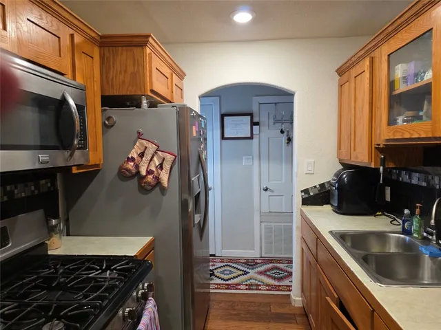 a kitchen with stainless steel appliances granite countertop a sink stove and refrigerator
