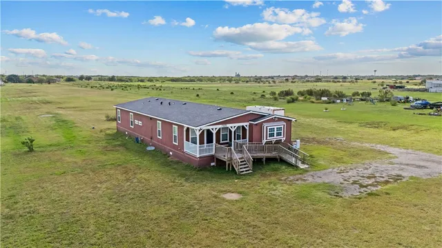 an aerial view of a house with big yard and large tree