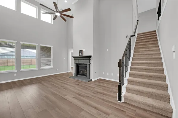 a view of a big house with a big yard potted plants and wooden fence