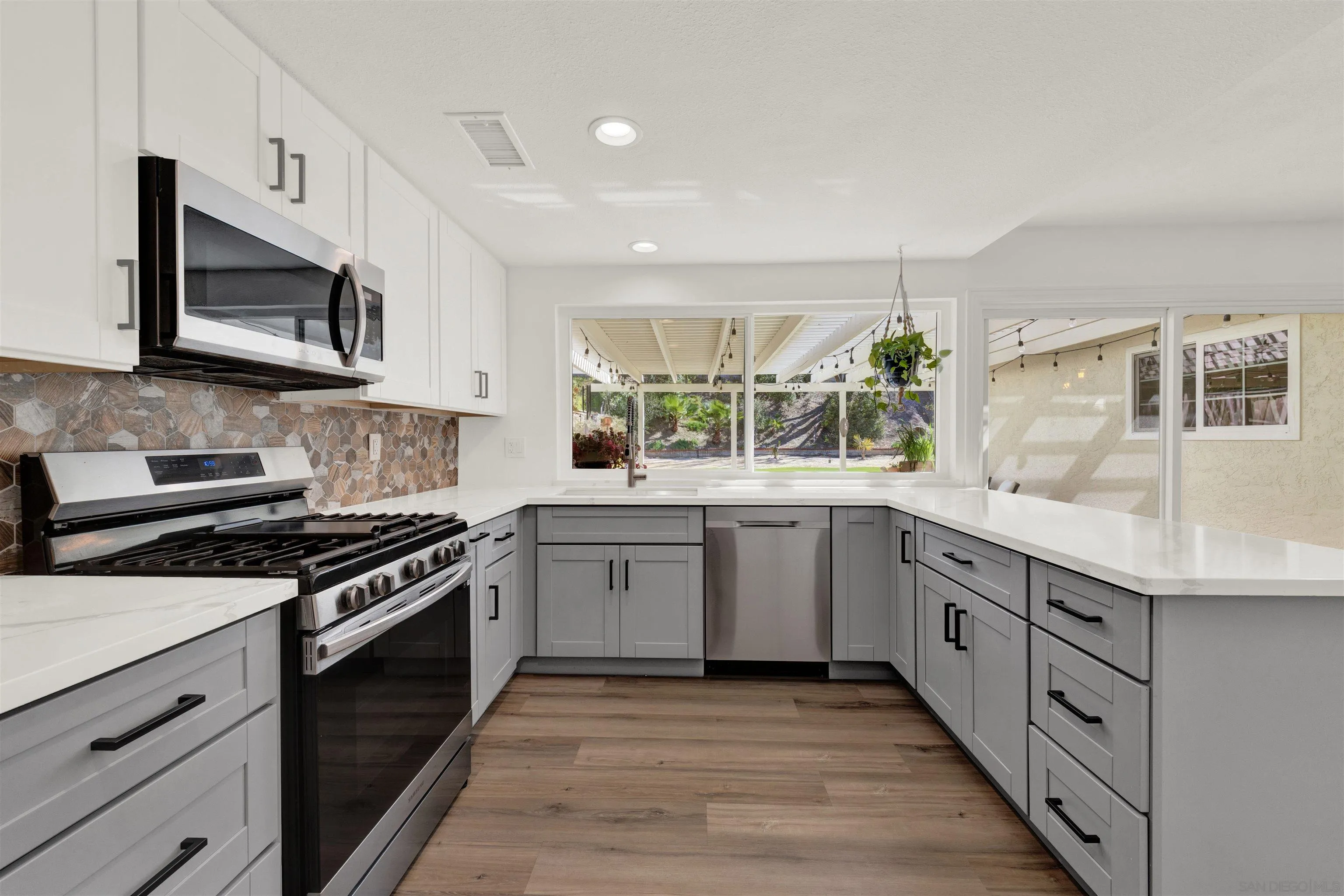 12435 Old Pomerado Road Poway, CA 92064 - Photo 17 of 53 a kitchen with stainless steel appliances granite countertop a stove a sink and a microwave