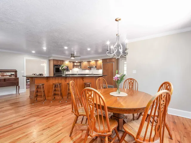 a dining room with furniture a chandelier and wooden floor