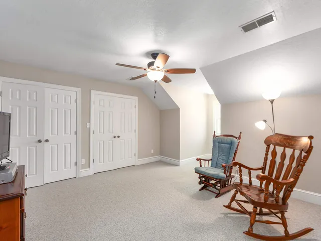 a living room with furniture a ceiling fan and a rug
