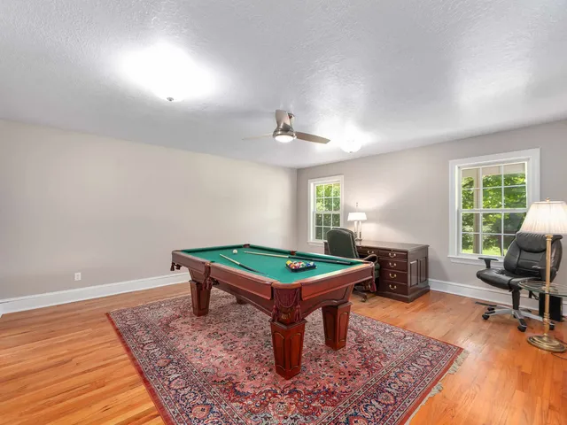 a room with furniture pool table and windows