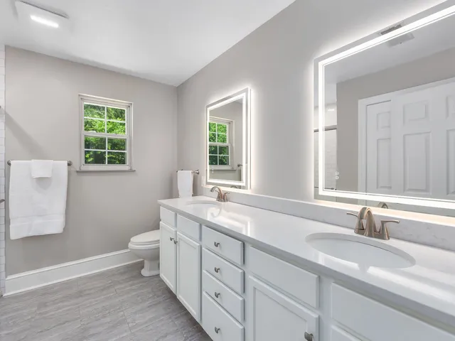 a bathroom with a granite countertop sink mirror and a window