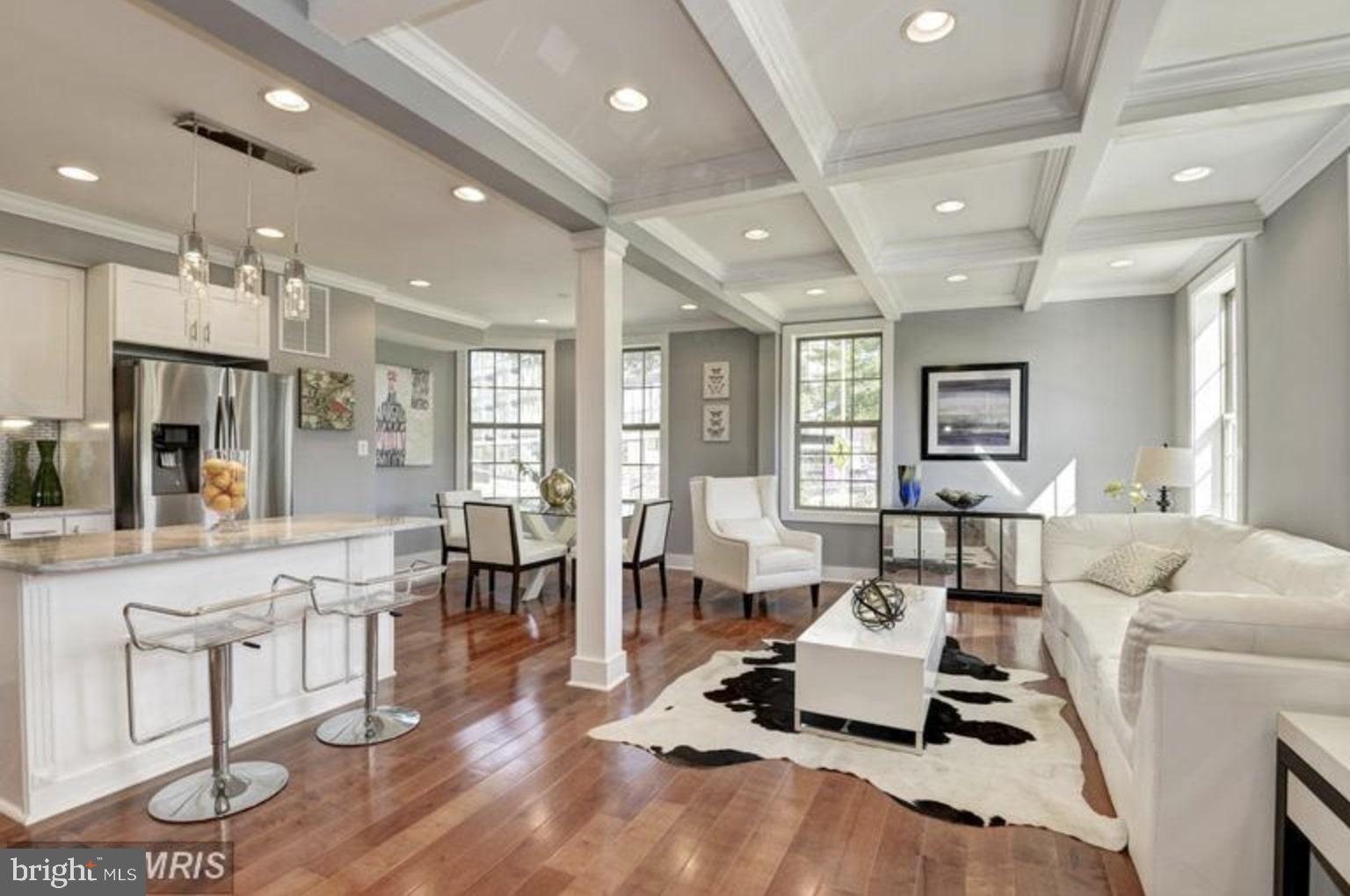 a living room with furniture and a dining table with wooden floor